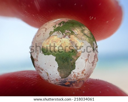 transparent globe ball between the fingers of a person