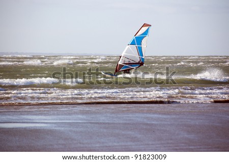 A wind surfer making full use of the wind on a english winters day.