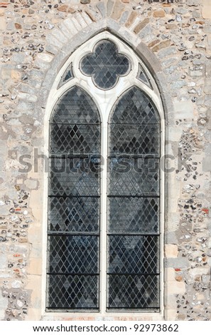 A stone window surrounded with a stone and flint arch.