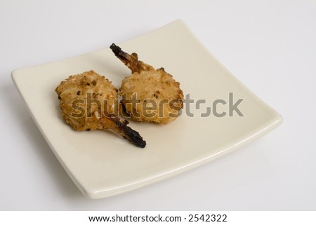Baked Coconut Shrimp on a square plate  in a yin yang position against a white background.