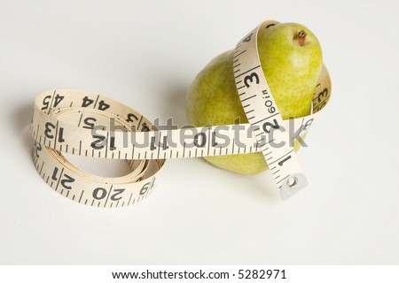 A fresh whole green pear fruit with a tape measure draped around the \'waist\' part. Could refer to weight loss eating healthy fruits or the pear shape figure. White background.