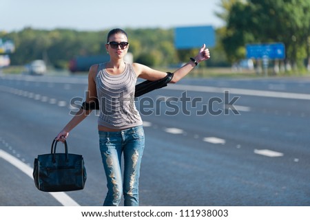 Photo slender young girl trying to stop the car on the road