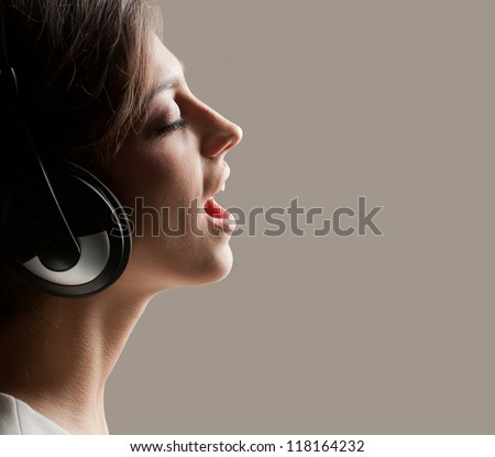 Photo in profile expressive girl in headphones singing emotionally