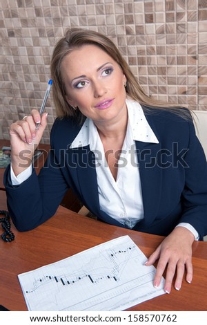 Business woman sitting at a table with a pen in hand to find solutions