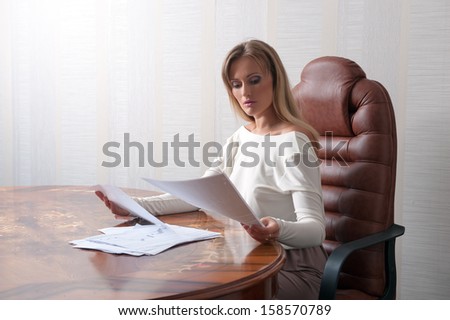 Business woman sitting at a table and reads
