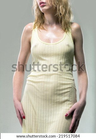 Wet dress fits snugly young girl, emphasizing all the advantages of her figure