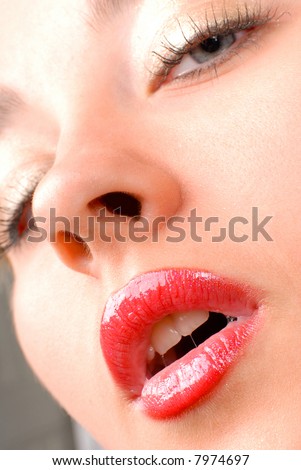 face of a beautiful girl with shiny pink lips and long black lashes