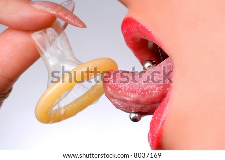 stock photo : mouth of a girl with pierced tongue licking a condom