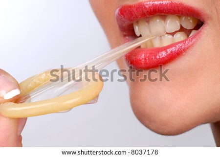 stock photo : mouth of a girl with pierced tongue licking a condom