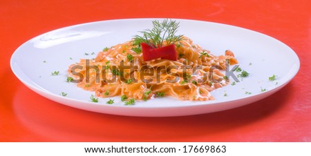 freshly cooked plate of macaroni decorated with fresh green herbs