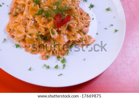 freshly cooked plate of macaroni decorated with fresh green herbs