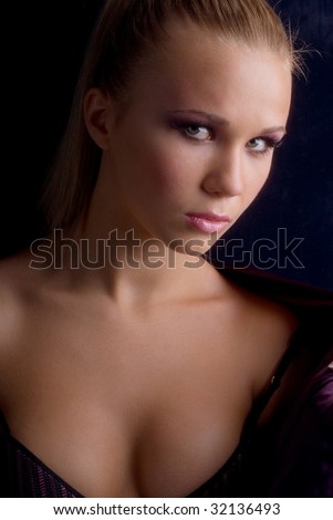 portrait of a young beautiful girl in their underwear and lilac jacket on a black background
