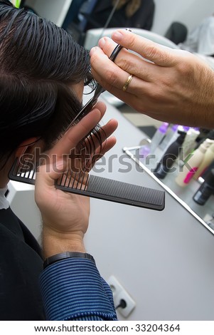 man trim young man with the help of scissors and comb