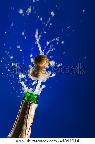 Close up of champagne cork popping on blue background