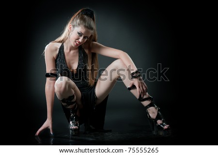 Portrait of a passionate amazonian woman with aggressive face in a sitting posture in studio
