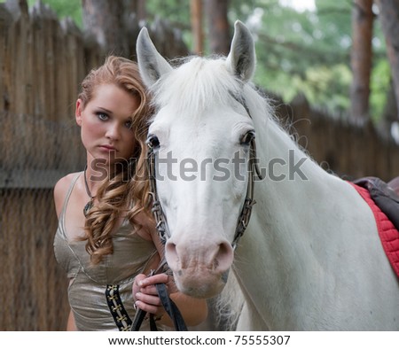  hairs and her nice horse on a wooden fence background - stock photo