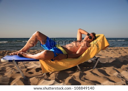 young man relaxing at the beach enjoying the sun