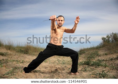 martial arts instructor exercising with a knife outdoor
