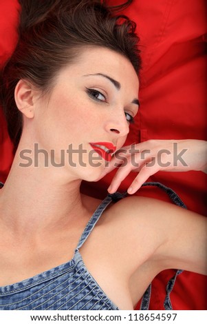 portrait of a beautiful girl lay down on a red jacket