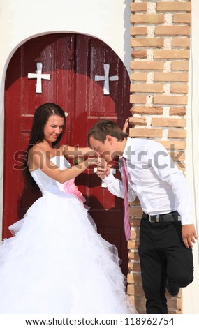 portrait of a beautiful bride and groom with a church on the background