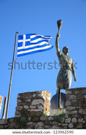 old statue and the greek flag in naypaktos greece