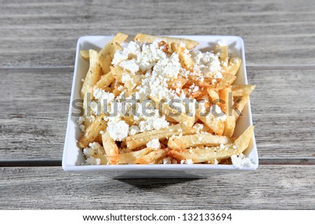 fried chips with oregano and cheese on a white bowl