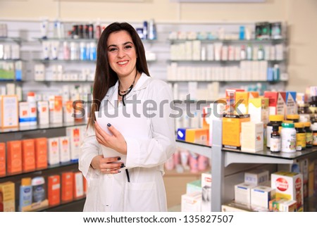 young female pharmacist on pharmacy store as a background