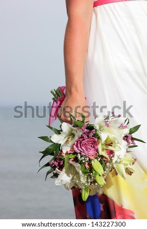 close up of a female  hand holding a flower bouquet