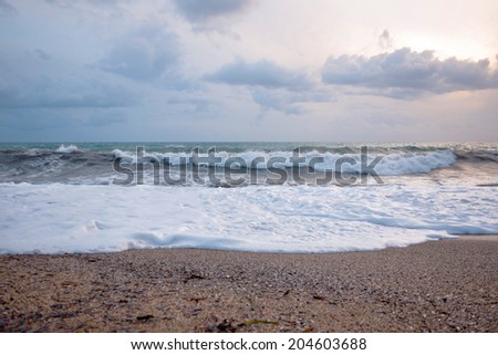 big waves hit the beach before a storm