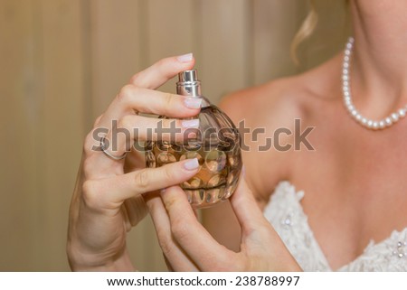 closeup of hands holding perfume bottle
