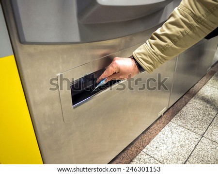 hand pick up a ticket from a vending machine for the metro station in Athens,Greece