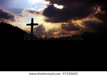 cross and god rays on the cloudy sky