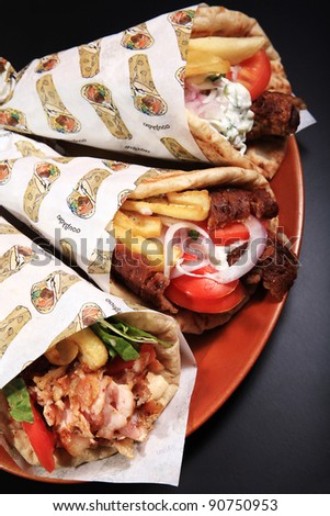 chicken lamb and pork rolled on a pita bread  on a black background