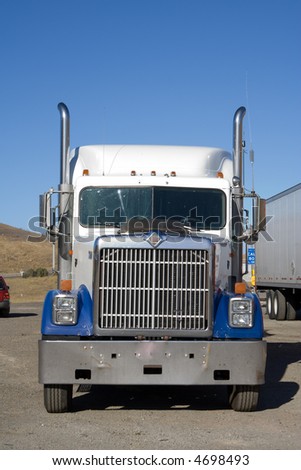 Frontal shot of a truck with blue sky and yellow hills on background