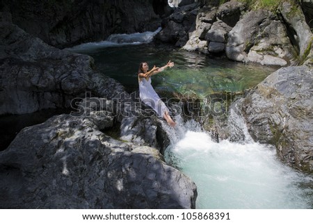 Beautiful young woman enjoying the purifying waters of a crystal clear mountain spring