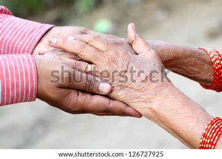 Young hand give help to old hand