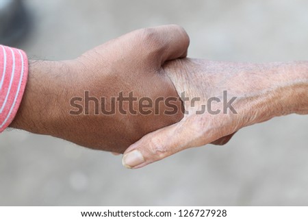 Young hand give help to old hand
