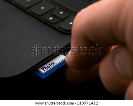 Inserting SD Card into personal computer ready for photo file transfer