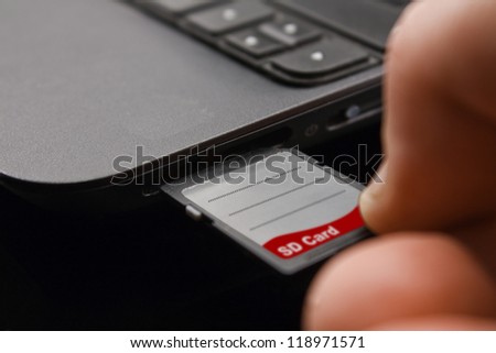 Plugging in SD Card into personal computer ready for photo file transfer