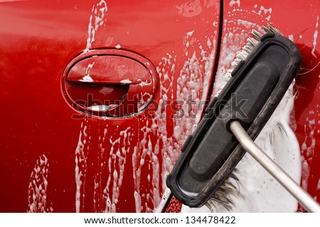 Washing the car with a soapy brush at a coin operated car jet wash