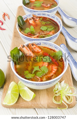 Tom Yum Goong - Thai hot and sour soup with king prawns and oyster mushrooms served with lime wedges.