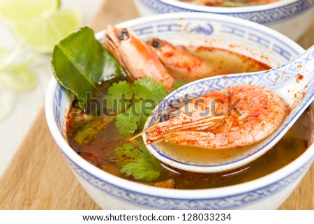 Tom Yum Goong - Thai clear hot and sour soup with king prawns and oyster mushrooms served with lime wedges.