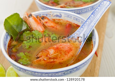 Tom Yum Goong - Thai clear hot and sour soup with king prawns and oyster mushrooms served with lime wedges.