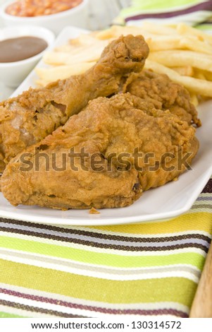 Fried Chicken & Chips - Chicken pieces on the bone coated in a spicy flour and deep fried served with fries, baked beans and gravy.
