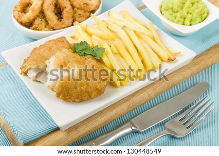 Fish & Chips served with mushy peas and deep fried breaded calamari. A popular British traditional meal!