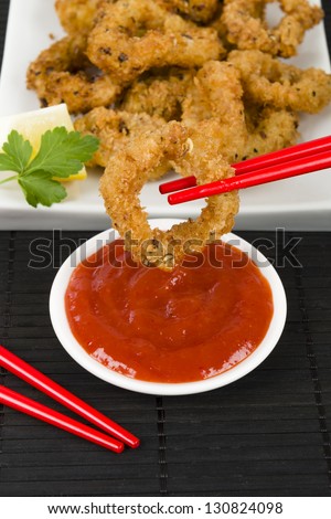 Ika Furai - Deep fried squid rings coated in panko breadcrumbs served with chili sauce and lemon wedges.