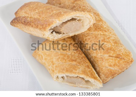 Sausage Rolls - Freshly baked sausage rolls - sausage meat wrapped in puff pastry - on a white background.