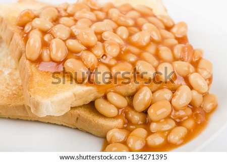 Beans on Toast - Slices of toasted white bread, buttered and topped with baked beans. Simple British breakfast meal.