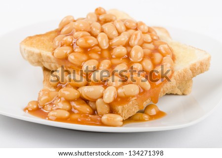 Beans on Toast - Slices of toasted white bread, buttered and topped with baked beans. Simple British breakfast meal.