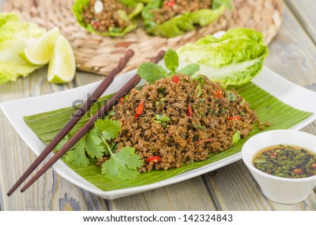 Larb - Lao minced beef salad with fish sauce, lime juice, roasted ground rice and fresh herbs served with lettuce leaves for wraps.